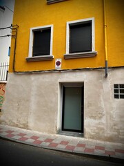 Fototapeta premium Yellow building with two windows and a door