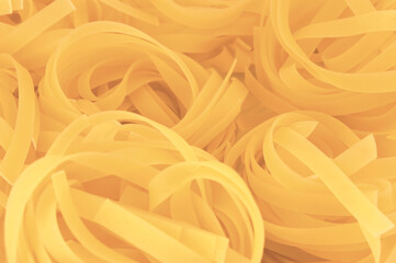 Traditional fettuccine ribbons pattern background, large detailed horizontal raw dry long uncooked...