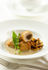 Pork roll stuffed with mushrooms and bacon, served with mustard sauce and mushrooms.