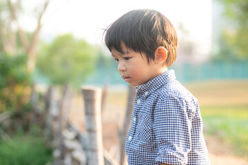 Asian preschool boy enjoying outdoor recreation city park sunset light