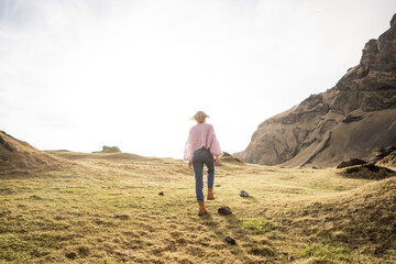 Fototapeta premium Fashion girl in a purple jacket poses in mountains