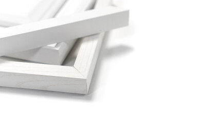 A pile of empty picture frames and mouldings on a clean white background