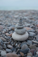 pebble stones stacked in a pyramid in the sand near the seashore
