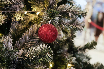 Christmas ball on pine tree branch blurred background