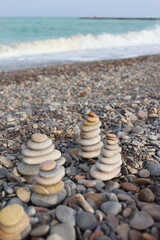 pebble stones stacked in a pyramid in the sand near the seashore