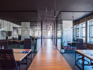 In a setting of modern, glass-walled business startup offices, the open, airy workspace reflects a...