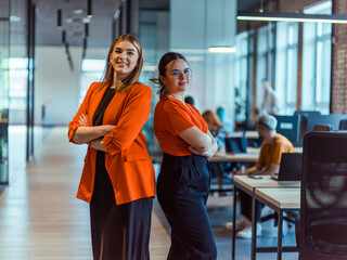 Group of determined businesswomen confidently pose side by side in a modern startup coworking...