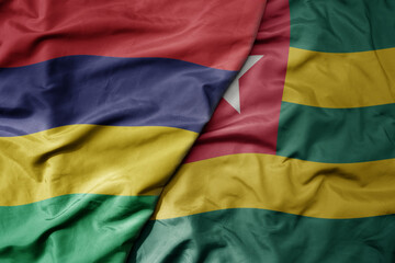 big waving national colorful flag of mauritius and national flag of togo .