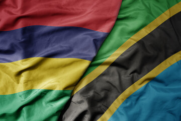 big waving national colorful flag of mauritius and national flag of tanzania .