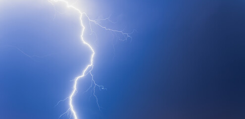 Lightning from the black and blue sky. Storm clouds.