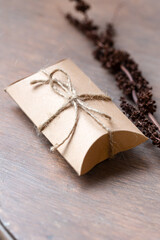 Craft package with ribbon on rustic table, present 