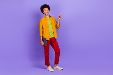 Full length photo of satisfied nice man wear trendy clothes empty space recommend buy modern device isolated on violet color background