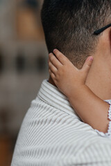 Fototapeta premium little hand on the father's neck, faceless