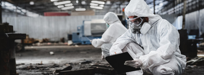 Scientist workers wear protection suit checking chemical contaminated oil in old factory. Protecting Against Hazards and Contamination. Emergency Response to a Radioactive Accident. - obrazy, fototapety, plakaty