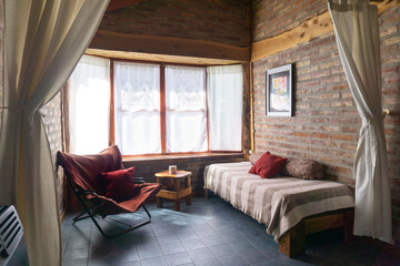Interior of a country house with brick walls and red pillows