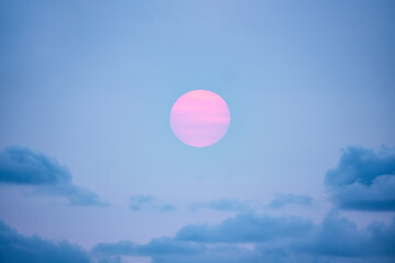 brightly colored sun behind the clouds