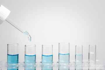 Chemistry laboratory tube glass, science laboratory research and development concept, flask, beaker, and test tubes with dropping blue liquid water sample test, scientific test tubes equipment.