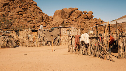 Houses in a Damara tribe village, near Twyfelfontein, Kunene, Namibia. Houses are constructed with tree branches and mud and covered with corrugated metal due to lack of straw.
