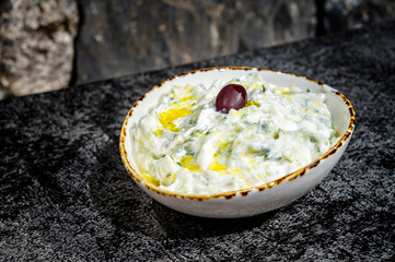 close-up view of a tantalizing bowl of tzatziki sauce, showcasing its rich and creamy texture....