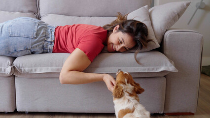 Portrait of a Woman laying on a Couch, Petting her Dog and Spending Time Bonding with Him. Lovely...