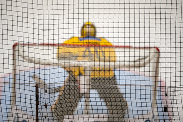Blurred Ice hockey goalie behind the protective net