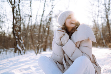 Obraz premium Happy woman walking on a snowy winter day outdoors. Beautiful woman having fun with snow in a snowy park. Walking concept.
