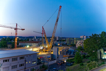 Mobile crane lifting and placing girder at highway enclosure construction site at City of Zürich on a beautiful late spring evening. Photo taken June 13th, 2023, Zurich, Switzerland.