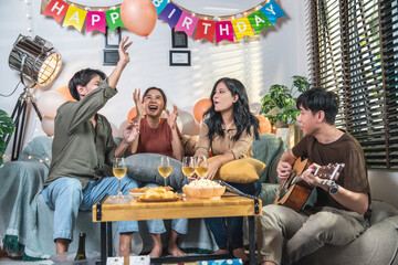 Group of male and female friends drinking wine, party celebrating birthday, friends all happy, clinking glasses together, laughing, smiling, wishing friends at home, sitting at home.