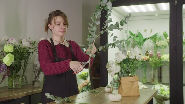 Young Woman Creating Beautiful Floral Arrangements in a Charming Flower Shop