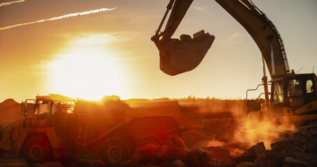 Construction Site On Sunny Evening: Industrial Excavator Loading Rocks Into A Truck. The Process Of...