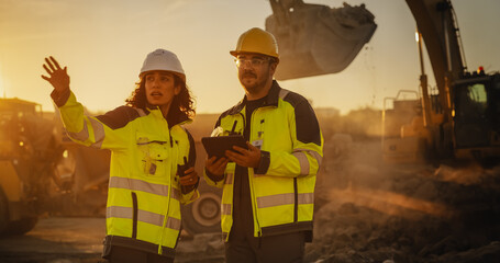 Cinematic Golden Hour Shot Of Construction Site: Caucasian Male Civil Engineer And Hispanic Female...