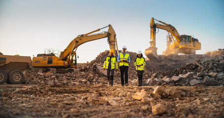 Construction Site With Excavators on Sunny Day: Diverse Team Of Male And Female Specialists Walking...