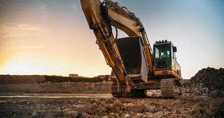 Construction Site On Sunny Evening: Industrial Excavator Driving To Complete Work Tasks Related To Building New Real Estate Project. Man Operating Heavy Machinery To Build New Apartment Complex. - obrazy, fototapety, plakaty