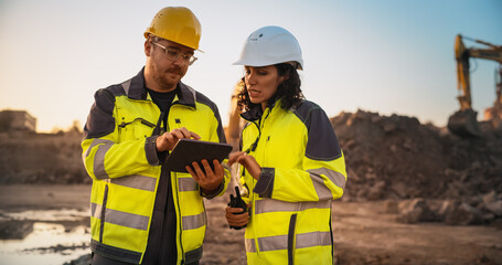 Caucasian Male Civil Engineer Talking To Hispanic Female Inspector And Using Tablet Computer On...