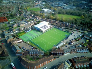 Aerial view of a soccer field with vehicles parked around the building