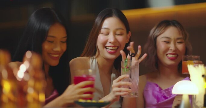 Beautiful Asian Woman Enjoying with Friend in Bar. They Drinking Cocktail Together in Bar Counter. Party, Lifestyle, Happiness, Cheerful and Celebration Concept.