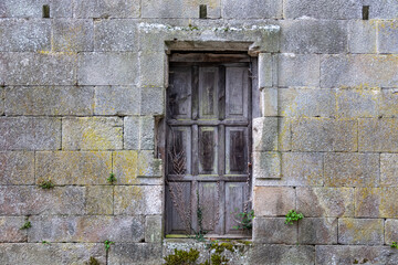 Fototapeta na wymiar Stone facade and wooden door. Monastery of Santa María la Real de Osera, San Cristóbal de Cea, Orense, Galicia.