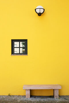Maison de vile au mur jaune et banc de marbre sous une lanterne. Seia, Serra da Estrela, Portugal.