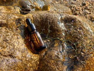 Cosmetic vial with essence on sea stone 
