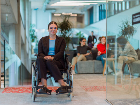 In a modern office, a young businesswoman in a wheelchair is surrounded by her supportive colleagues, embodying the spirit of inclusivity and diversity in the workplace