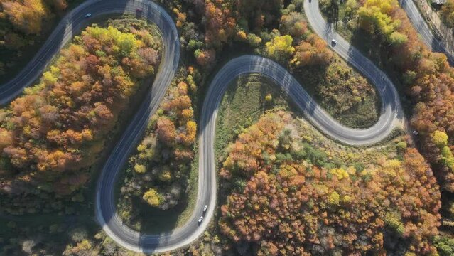 Curvy mountain roads in autumn. Vehicles in motion on winding mountain roads. 