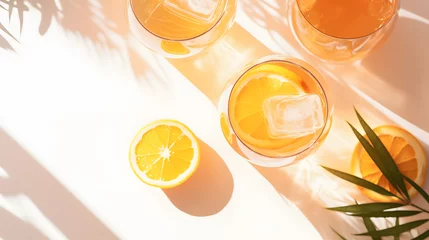 Fotobehang Summer orange cocktails with citrus fruits on white background. Hard seltzer, lemonade, refreshing drinks, low alcohol mocktails, summer party concept. Trendy palm leaf shadow and sunlight, sun. © Prasanth