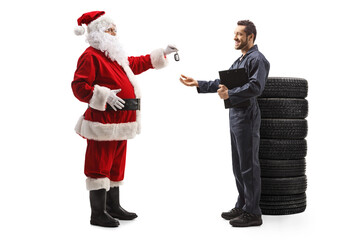 Full length profile shot of santa claus giving car keys to a mechanic