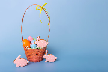 Fototapeta na wymiar Cute pink gingerbread in the form of a rabbit and a basket with decorative Easter eggs