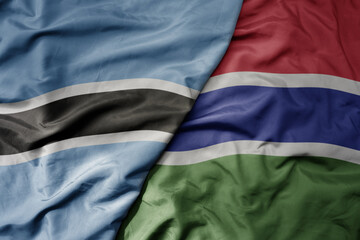 big waving national colorful flag of botswana and national flag of gambia .