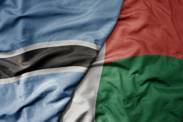 big waving national colorful flag of botswana and national flag of madagascar .