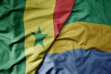 big waving national colorful flag of senegal and national flag of gabon .