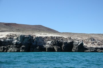 the rocks around the shore are empty from the sea and sand © Wirestock