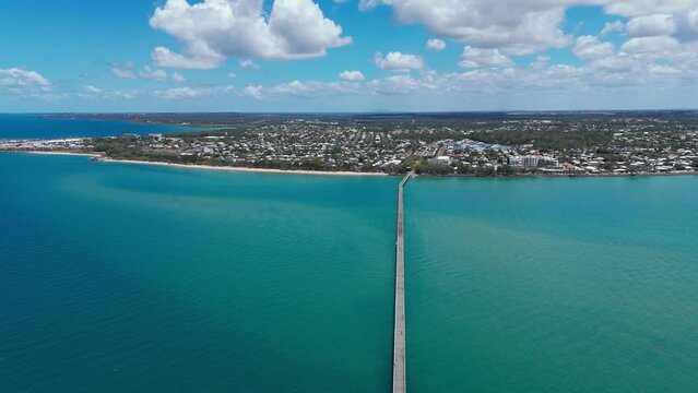 Aerial footage of Urangan pier and Hervey Bay on a sunny day in Queensland, Australia