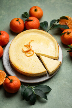cheesecake agrumes clémentine orange speculoos fait maison sur table avec agrumes et feuilles vertes	